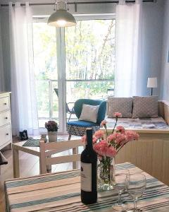 尤斯托尼莫斯基Apartament Ku Morzu II Ustronie Morskie的客厅的桌子上放一瓶葡萄酒