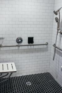 奥克兰Signature Inn Oakland的浴室内铺有白色瓷砖的淋浴和长凳