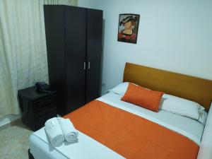 麦德林Hotel Gran Imperio的一间卧室配有一张床和一个黑色橱柜