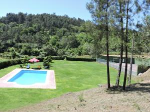 塞洛里库迪巴什图Casa das Vessadas的一个带游泳池和树木的大院子