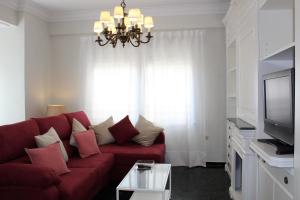 阿利坎特Port-Beach Alicante 2的客厅配有红色沙发和电视