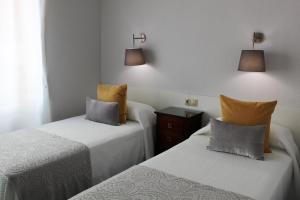 阿利坎特Port-Beach Alicante 2的两张睡床彼此相邻,位于一个房间里