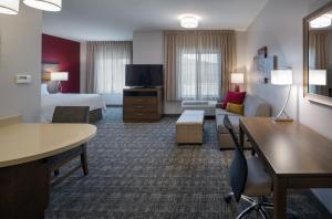 凤凰城Staybridge Suites - Phoenix – Biltmore Area, an IHG Hotel的酒店客房设有床和客厅。