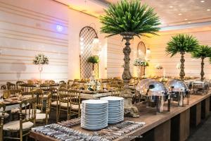 马卡埃Mercure Macae的一个带桌椅和棕榈树的宴会厅