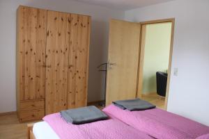 福格茨堡Winzerhof Senn的一间卧室配有两张带粉色床单和镜子的床