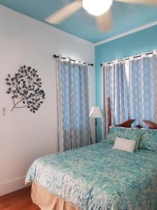 伯利兹城大屋酒店的一间卧室配有一张带蓝色床罩的床