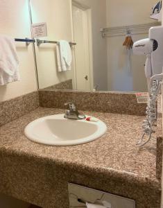 拉斯维加斯拉斯维加斯速8酒店的浴室的柜台设有水槽和镜子