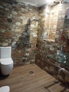 UcedaSuite Love Jacuzzi (Casas Toya)的带淋浴和卫生间的石墙浴室