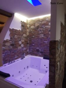 UcedaSuite Love Jacuzzi (Casas Toya)的砖墙客房内的大浴缸