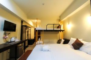 清莱班珀尔迪丁旅馆的一间卧室配有一张床和一张双层床。