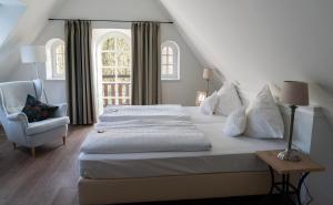 DuvenstedtHotel Alster Au的卧室配有床、椅子和窗户。