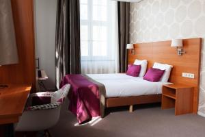 苏斯特贝赫Hotel Kontakt der Kontinenten的配有紫色枕头的床的酒店客房