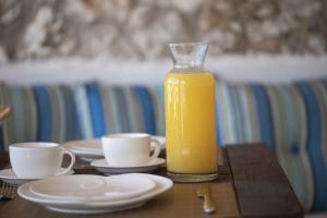 瓦西利基Villa Del Mar的桌上放着一瓶橙汁和两杯