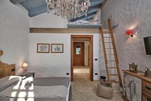 波尔佩纳泽德尔加尔达Pietra Cavalla - Ranch & Resort的一间卧室配有一张床和一个吊灯