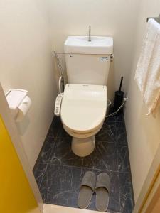 德岛Melody Heim 2C的一间带卫生间和一双拖鞋的浴室