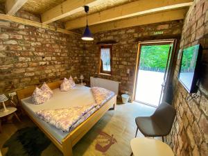 DubovskoHoliday park Hajducka cesma的一间卧室设有一张床和石墙