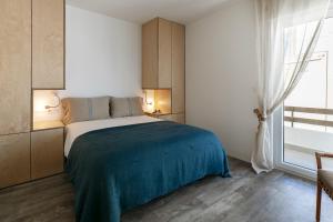 孔索拉桑Mare Cheia: Beach and Surf Apartment 2的一间卧室配有一张带蓝色毯子的床和窗户。