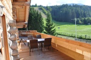 JenigBärenhütte Tröpolach-Nassfeld的木制阳台配有桌椅