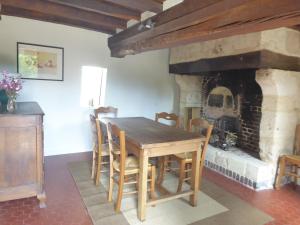 Le Mesnil-sur-BlangyGite de la Saulnière的一间带桌子和壁炉的用餐室