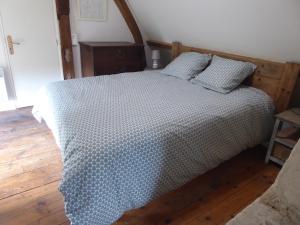 Le Mesnil-sur-BlangyGite de la Saulnière的一间卧室配有一张带 ⁇ 子毯子的床