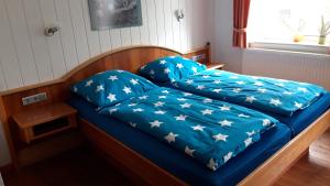 申贝格Gasthaus Zehrermühle的一张带蓝色床单和星光的床