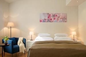 布拉格沃塞洛瓦公寓酒店的一间卧室配有一张床和一张蓝色椅子