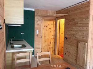 布勒伊-切尔维尼亚House Cervinia Apartments的厨房设有绿色的墙壁和水槽及椅子