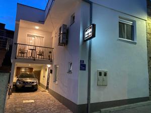 莫斯塔尔Apartments & Rooms Mostar Story的停在大楼旁边的停车场的汽车