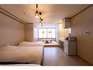 高山BEYOND HOTEL Takayama 3rd - Vacation STAY 82211的带两张床的客房和一间带窗户的厨房