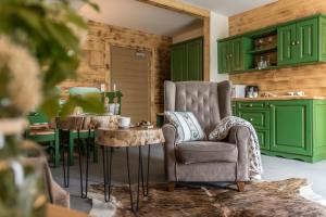 扎科帕内Villa Adamo&SPA的厨房配有绿色橱柜、椅子和桌子