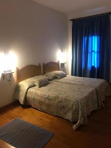 SeoaneCasa Ferreiro的一间卧室配有一张床、两盏灯和一个窗户。