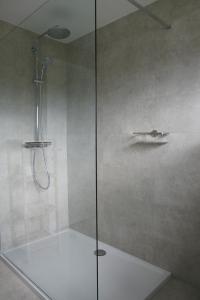 贝拉克尔Vakantiewoning Hoge Zavel的浴室里设有玻璃门淋浴