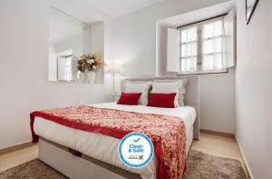 埃武拉Casa Becco dos Assucares, com free garagem - Centro Histórico的白色卧室配有一张带红色枕头的大床