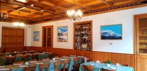 艾罗洛Hotel Des Alpes - Restaurant & Pizzeria的一间设有桌椅的山景餐厅