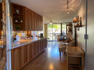 基黑Perfect for families and couples - Maui Sunset A-203的一间带木制橱柜的厨房和一间客厅