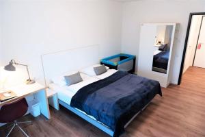 汉堡Gästehaus Hansa Residence的一间卧室配有一张床、一张书桌和一面镜子
