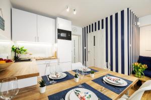 波德贝Apartament 11B Blue Marine Poddąbie的厨房以及带桌椅的用餐室。