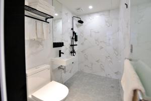 台东Home Rest Hotel 2的白色的浴室设有卫生间和水槽。