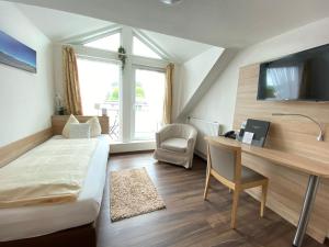 达登科赫酒店的一间卧室配有书桌、一张床、一张桌子和椅子