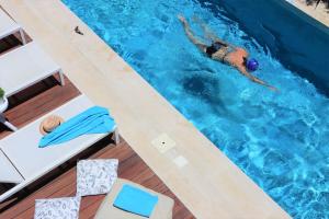 加拉塔斯Fos Villa, a Luxe House with Private Heated Pool的妇女在游泳池游泳