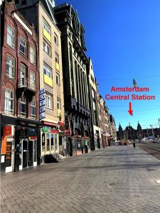阿姆斯特丹Dam Hotel的一条空的城市街道,有建筑和红箭