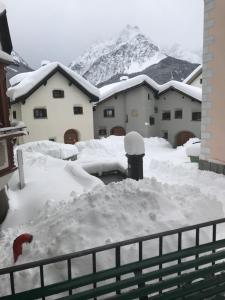 施库尔查萨瓦拉尔住宿加早餐公寓酒店的雪覆盖的栅栏,背景是山