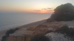韦尔瓦Duplex en Huelva a 15 minutos en coche de las mejores playas de España的日落时分享有海滩和大海的景致