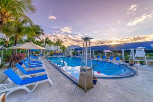基韦斯特宜必思海湾度假酒店的一个带蓝色椅子和滑梯的大型游泳池