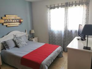 拉卡莱塔Salitre的一间卧室配有一张床和一张书桌及电视