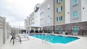 韦科Candlewood Suites Waco, an IHG Hotel的大楼前设有游泳池的酒店