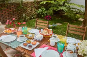 蓬塔德尔加达Casadacidade的一张木桌,上面摆放着早餐食品和饮料