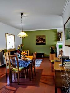 塞图巴尔Páteo memória, casa do beco的一间配备有桌椅的用餐室和绿色的墙壁