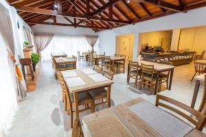 波梅罗迪LENA ROSA Premium Hotel的餐厅设有木桌、椅子和柜台