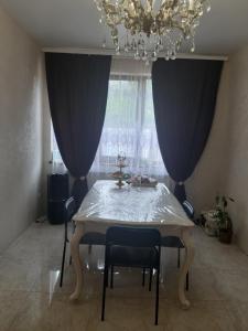 敖德萨ARKADIYA HOUSE的餐桌、两把椅子和吊灯